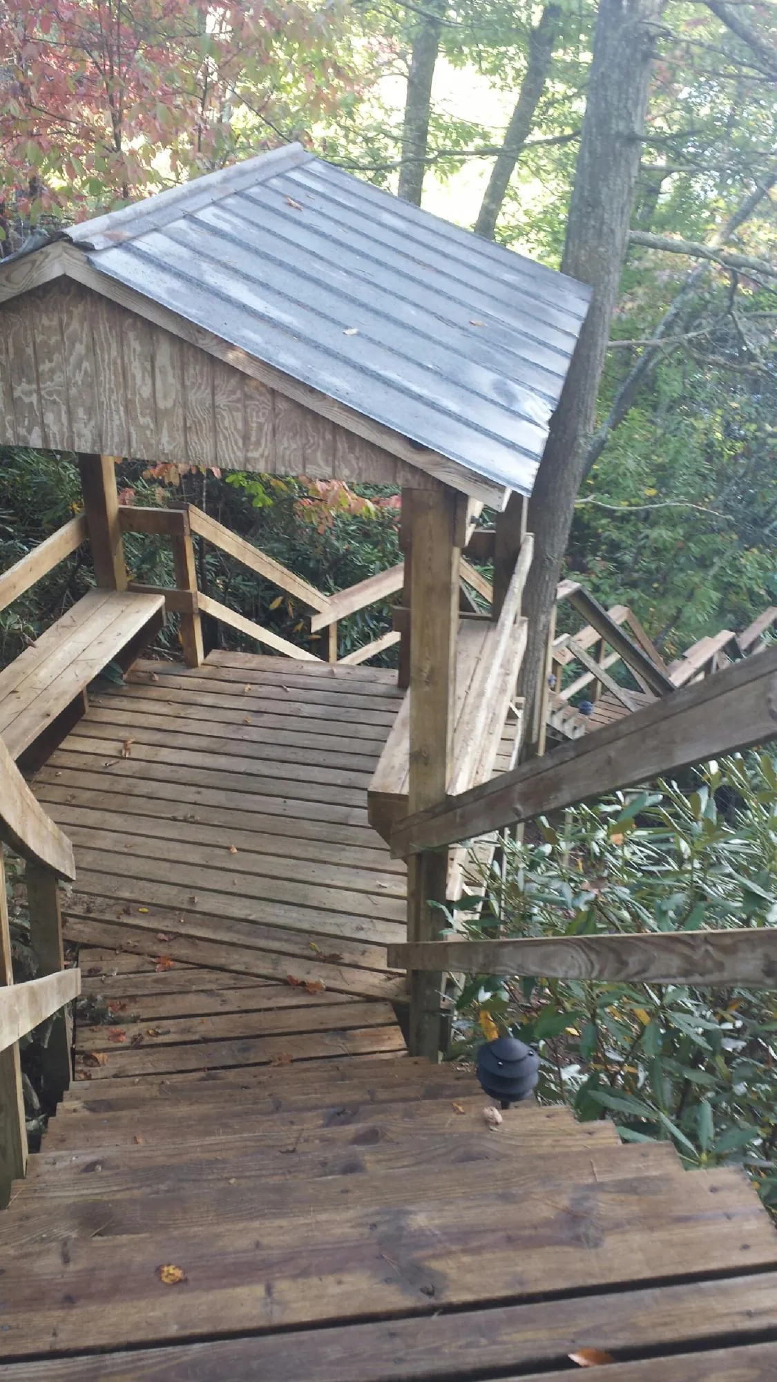 Metal roofed shelter over wooden steps on a wooded walkway — Skylight Repair & Installation work by our crew in Canton